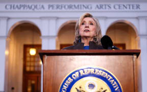 Former US Secretary of State Hillary Clinton speaks to the press after her a deposition with the House Oversight Committee as they investigate links to convicted sex offender Jeffrey Epstein, in Chappaqua, New York, on February 26, 2026. Clinton testified behind closed doors on Thursday before a congressional committee investigating the late convicted sex offender Jeffrey Epstein and his accomplice Ghislaine Maxwell. Former president Bill Clinton is scheduled to answer questions the following day from the Republican-led House Oversight Committee about his relations with Epstein, who died in a New York jail cell in 2019 while awaiting trial. (Photo by CHARLY TRIBALLEAU / AFP)