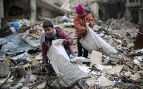 Syrian youths collect wood from rubble in Damascus to use for heating and cooking.