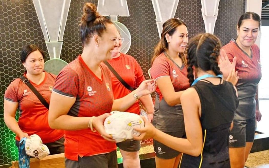 Tala coach Jaqua Pori-Makea Simpson (standing left) and members of the team, with local netball players in Tonga earlier this month. Photo: Tonga Netball