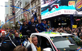 Peter Burling and Team NZ wave to crowds on Queen Street