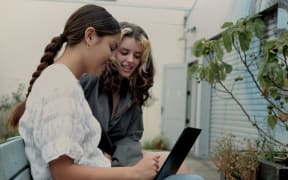 Two young people using an intergrated Māori keyboard.