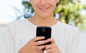 Funny teenage boy looking at the mobile
