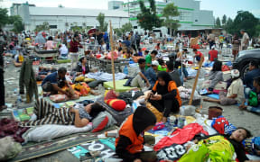 Medical team members help patients outside a hospital after an earthquake and a tsunami hit Palu, on Sulawesi island.