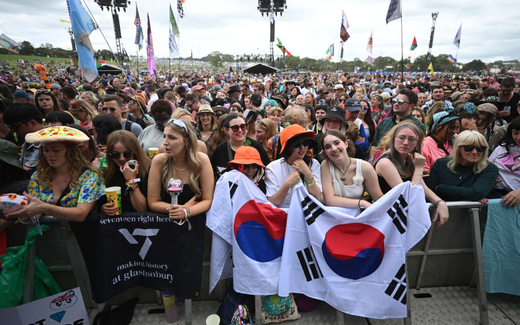 Fans of K-Pop band Seventeen wait to see them perform on the Pyramid Stage on the third day of the Glastonbury festival at Worthy Farm in the village of Pilton in Somerset, southwest England, on June 28, 2024. The festival takes place from June 26 to June 30. (Photo by Oli SCARFF / AFP)