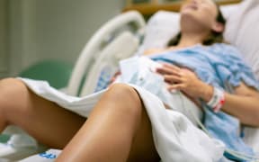 A woman screaming in pain from strong contractions.