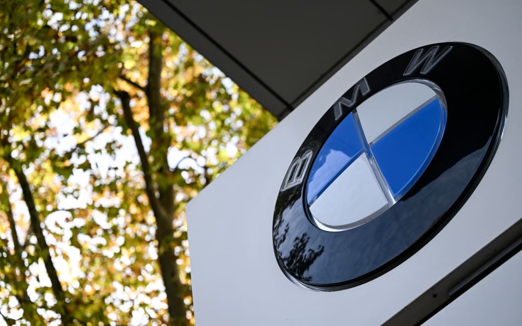 (FILES) This file photograph shows a logo of German automotive brand BMW displayed on BMW dealership in Frankfurt am Main, western Germany, on November 4, 2025. German carmaker BMW is to recall hundreds of thousands of cars worldwide over a potential risk of engine starters sparking a fire, a company spokesman confirmed to AFP on February 11, 2026. (Photo by Kirill KUDRYAVTSEV / AFP)