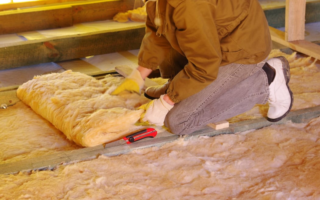 13534764 - construction worker thermally insulating house attic with glass wool