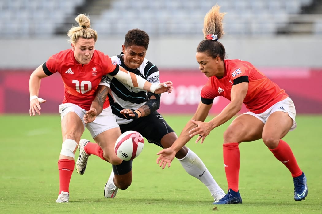Two British players fight for the ball with Fiji's Reapi Uluinasau in the women's bronze medal rugby sevens match at the Tokyo Olympics 2021.