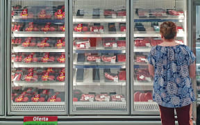 A costumer checks the beef section of a supermarket in Curitiba, Brazil, on February 23, 2023. - As of February 23, 2023, Brazil temporarily suspended its beef exports to China, its main buyer, following the official health protocol after a case of bovine spongiform encephalopathy was confirmed by the Ministry of Agriculture. Brazil made the announcement on February 22, 2023, after detecting a case of the so-called "mad cow" disease in the northen state of Para.