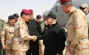 Iraqi Prime Minister Haider al-Abadi (C-R) shaking hands with army officers upon his arrival in Mosul