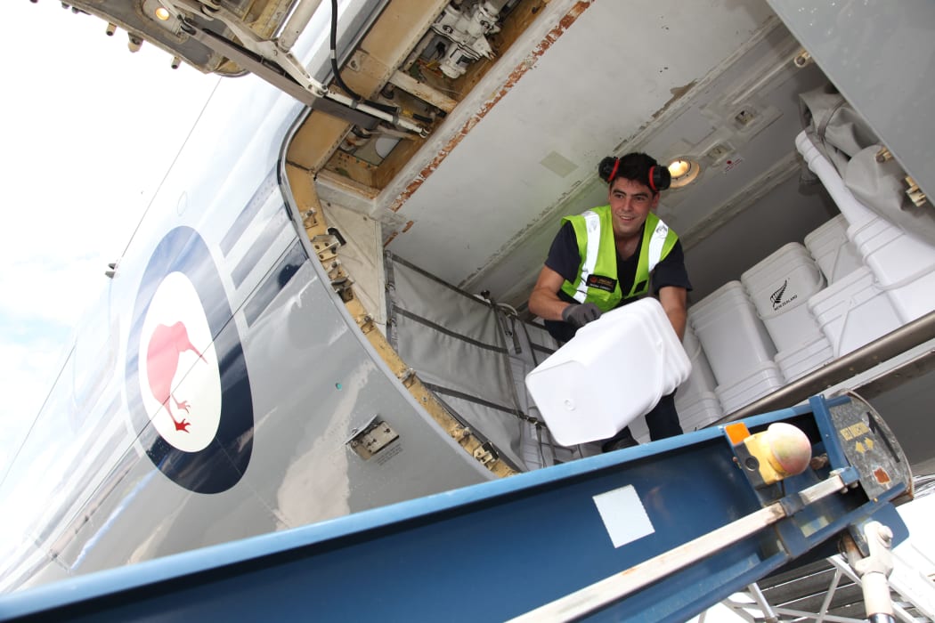 LAC Zinzan Currey unloads water containers from a RNZAF Boeing 757 at Bauerfield Airport, Port Vila, Vanuatu, part of an 11 tonne delivery of relief supplies for Ambae Island.
