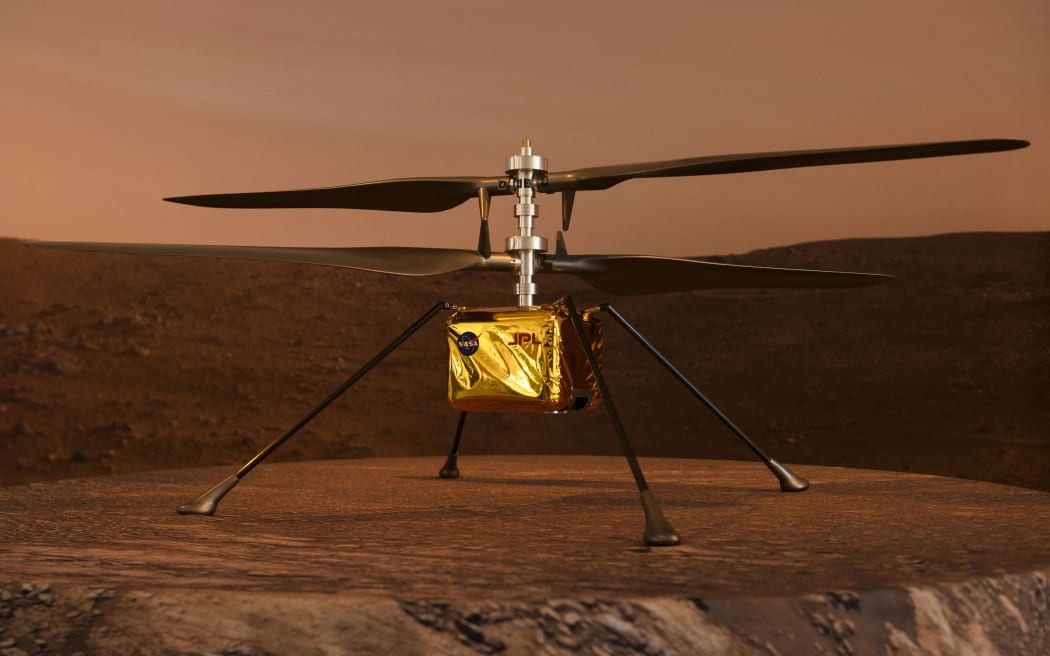 A full scale model of the experimental Ingenuity Mars Helicopter, which will be carried under the Mars 2020 Perseverance rover, is displayed at NASA's Jet Propulsion Laboratory (JPL) on 16 February 2021 in Pasadena, California.