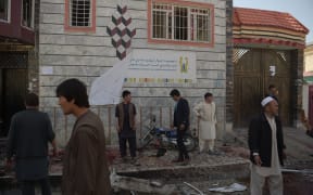 Afghan residents inspect the site of a suicide bombing outside a voter registration centre in Kabul on April 22, 2018