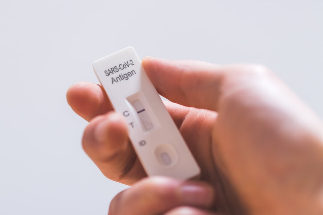 Close up of fingers holding express antigen covid test, negative result