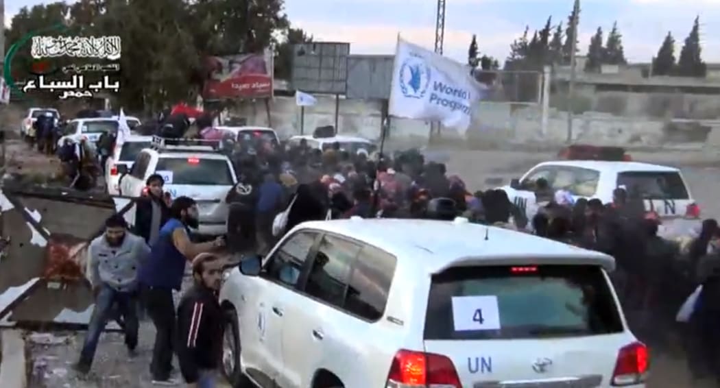 A convoy of United Nations, Red Crescent and World Food Programme vehicles escorting civilians in Homs on Monday.