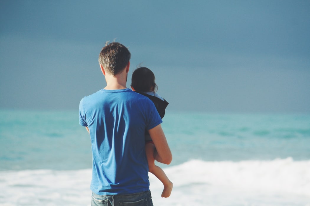 Father and child walk along the beach
