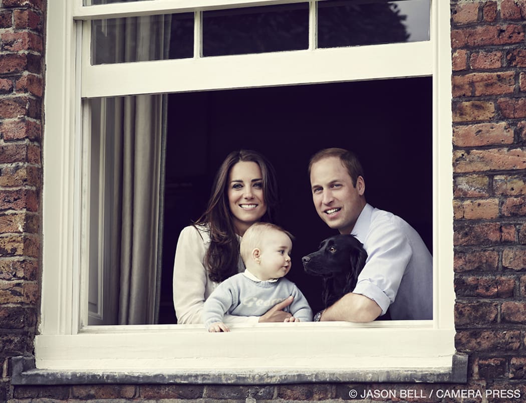 Prince William and Catherine, Duchess of Cambridge pose with their son Prince George and pet dog Lupo at Kensington Palace.