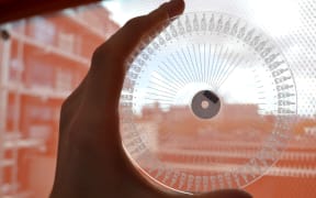 An example of a transparent disc, with carved channels and wells visible, used to analyse milk samples.