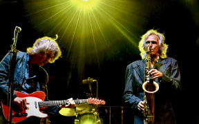 Chris White (right) playing saxophone in the Dire Straits experience