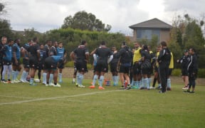 Head coach John McKee (far left) looks on as the Fiji squad huddle up during training.