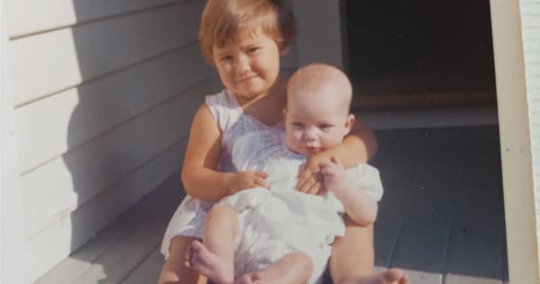 Sue Watson's sister Wendy holding her as a baby at their home in Auckland.