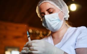 A medical worker vaccinates an employee of the Olympic Reserve Equestrian Sports School against COVID-19 in Novosibirsk, Russia.