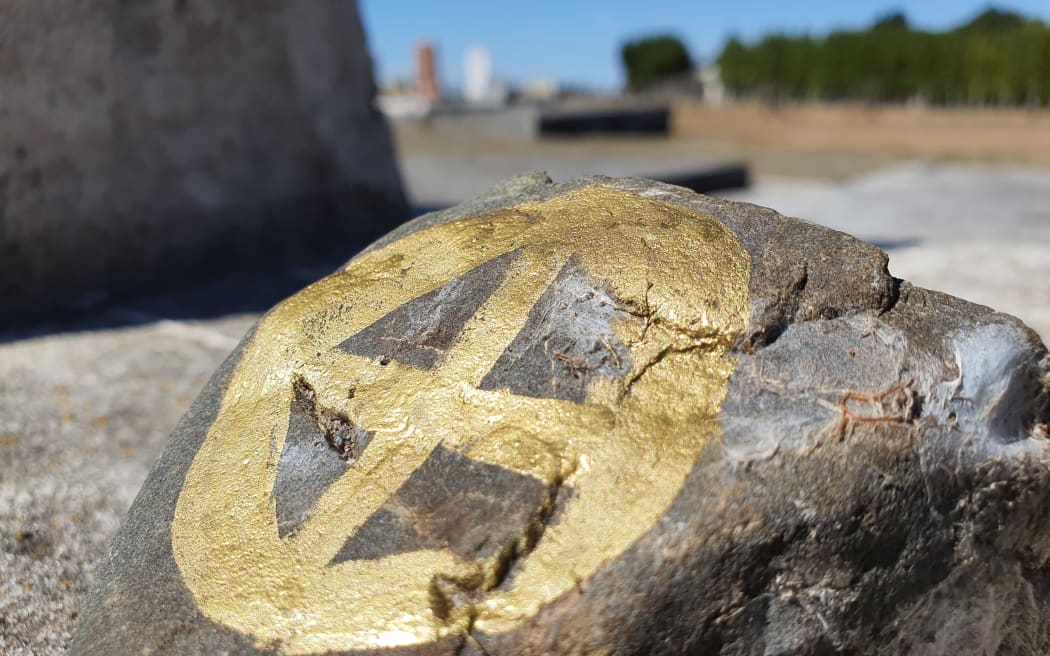 A stone painted with the Scandi wheel symbol, laid to remember Scandinavian settlers buried in Norsewood