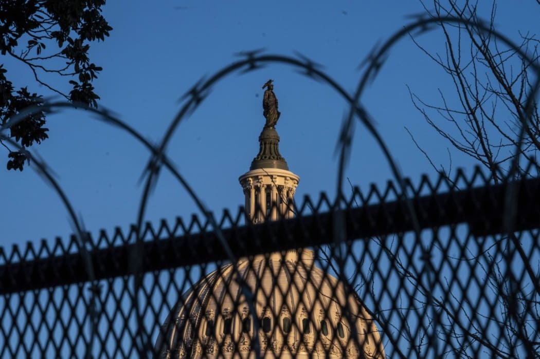 The exterior of the U.S. Capitol building is seen through barbed wire fencing at sunrise on February 8, 2021 in Washington, DC.