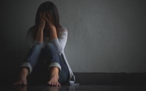 sad woman hug her knee and cry. Sad woman sitting alone in a empty room.