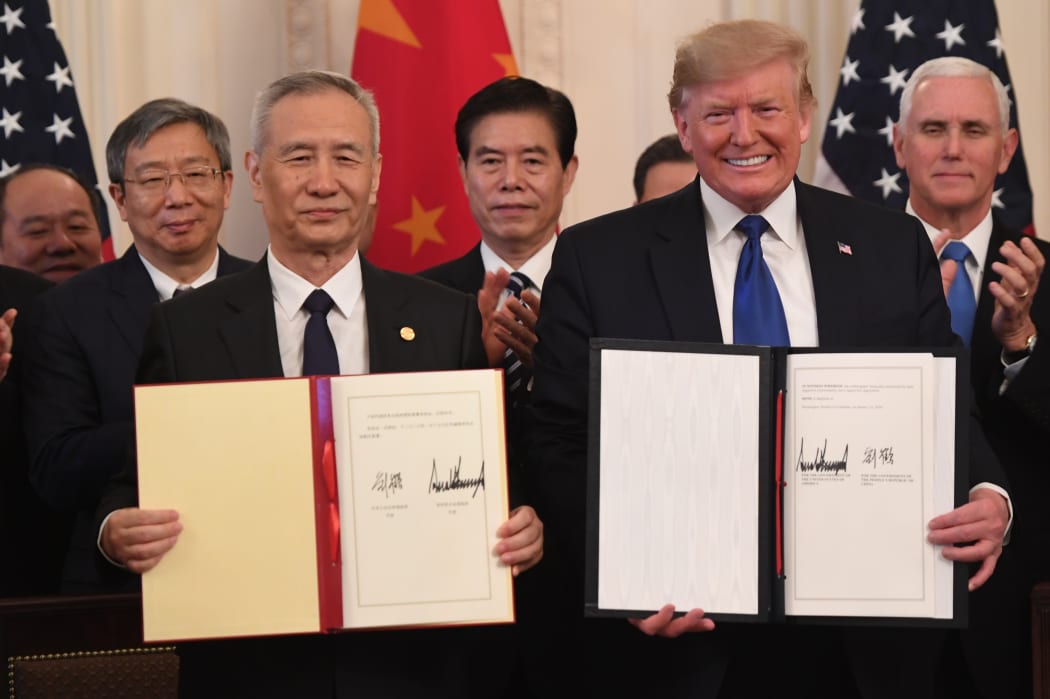 Chinese Vice Premier Liu He and US President Donald Trump display the signed trade agreement between the US and China in the East Room of the White House in Washington, DC, January 15, 2020.