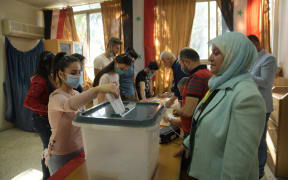 A Syrian woman casts her vote at a polling station in Aleppo on May 26, 2021.
