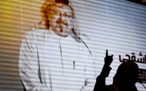 Nobel Peace Prize laureate Yemeni Tawakkol Karman stands in front of a digital image of Jamal Khashoggi as she speaks during a commemoration event of Khashoggi's supporters.
