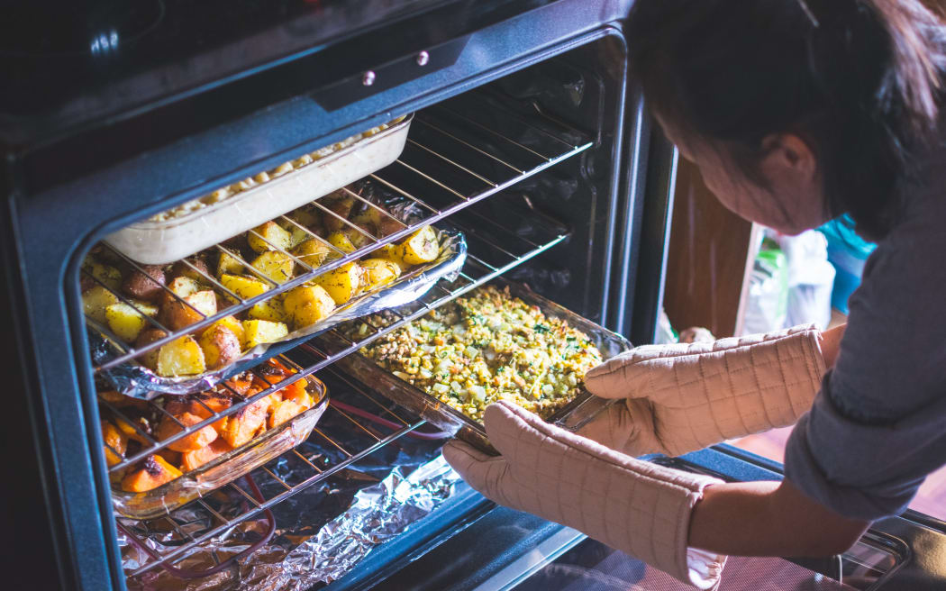 woman putting food in the oven