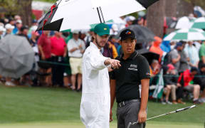 Jeunghun Wang talks to his caddie during the 2017 Masters Tournament.