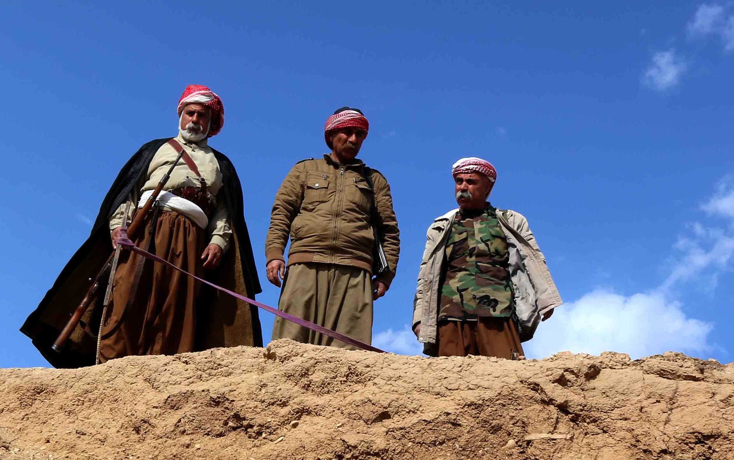 Members of the Yazidi community search for missing relatives in the remains of people killed by IS a day after Kurdish forces discovered a mass grave near the Iraqi village of Sinuni, in the northwestern Sinjar area.