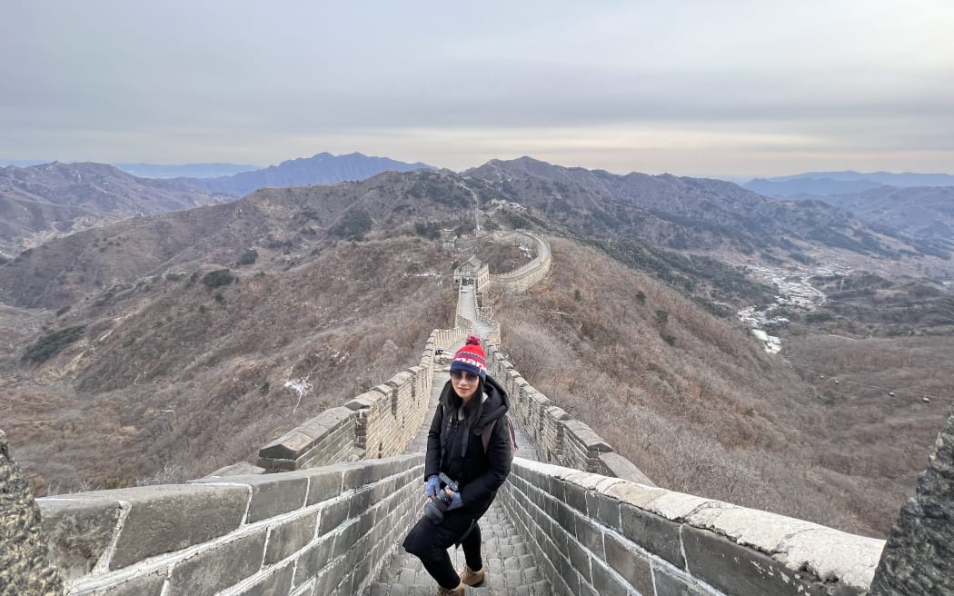 Chen Liu standing on the Mutianyu section of the Great Wall of China. It is a clear, cold day.