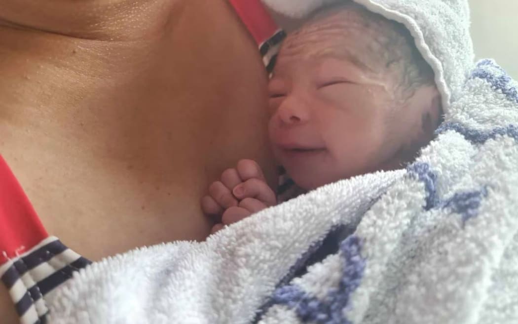 New parents Keith and Gill Bay pictured with their son Nathanael in an ambulance on the way to Waitākere Hospital after the premature baby boy was unexpectedly born in a Costco Westgate disabled toilet yesterday.

Photos supplied by NZH