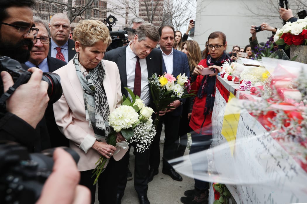 Ontario Premier Kathleen Wynne and Toronto Mayor John Tory brings flowers on April 24, 2018 to a makeshift memorial for victims in the van attack in Toronto, Ontario.