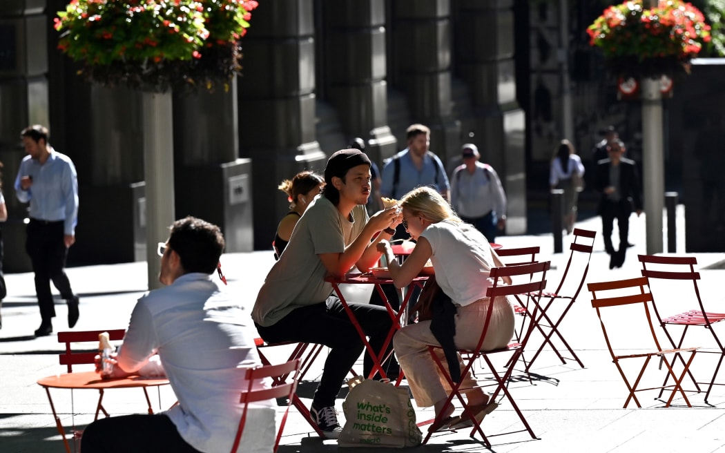 People spend their lunch hour in the central business district of Sydney on November 3, 2020. (Photo by Saeed KHAN / AFP)