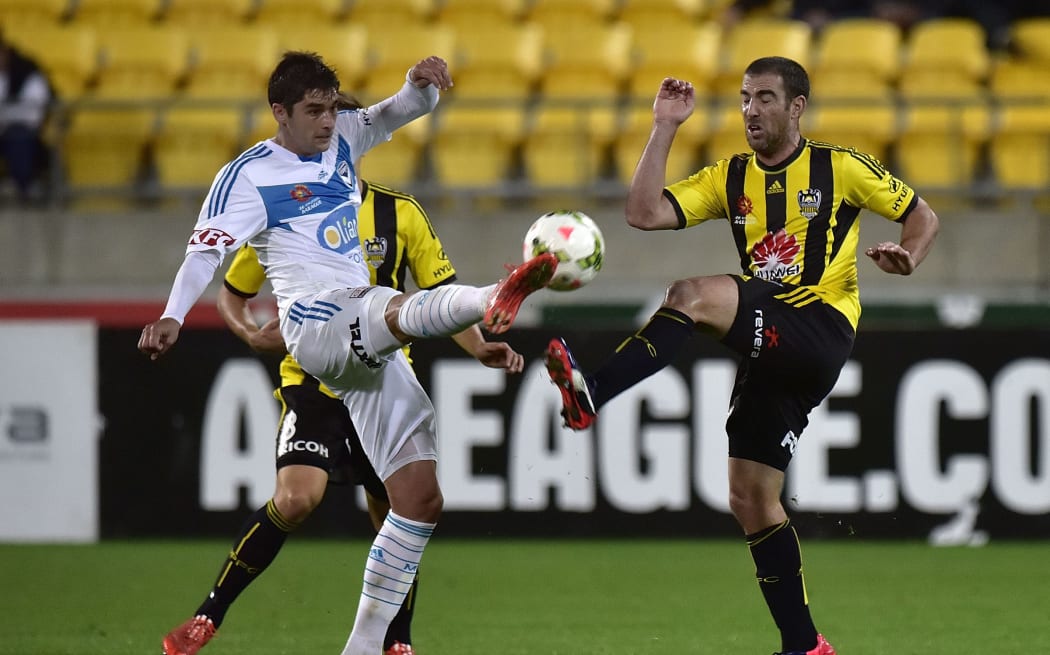 Gui Finkler of the Melbourne Victory battles for the ball against Manny Muscat of the Phoenix.