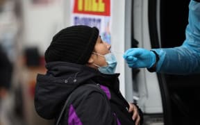 NEW YORK, USA - DECEMBER 28: A woman is getting a Covid-19 test at a Covid-19 testing center next to the Queens Hospital Center as hundreds of residents line up to get Covid-19 test in Queens of New York, United States on December 28, 2021 as Omicron rises around the country.