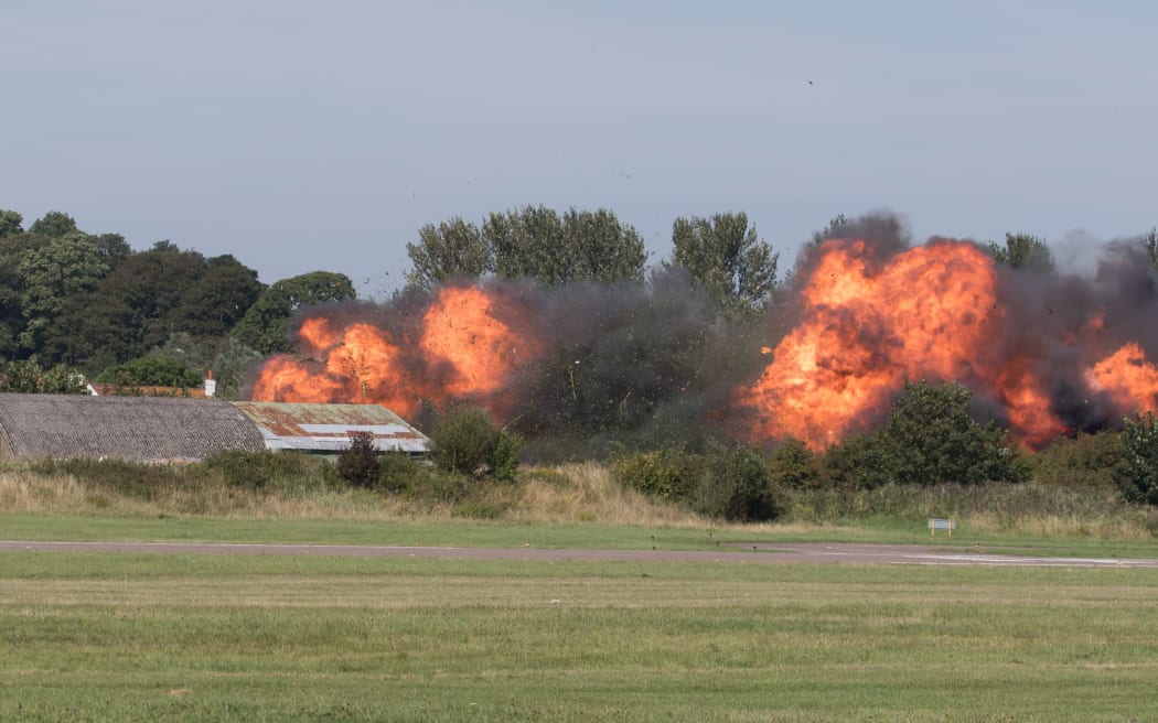 Flames erupt from the site of the fatal crash.