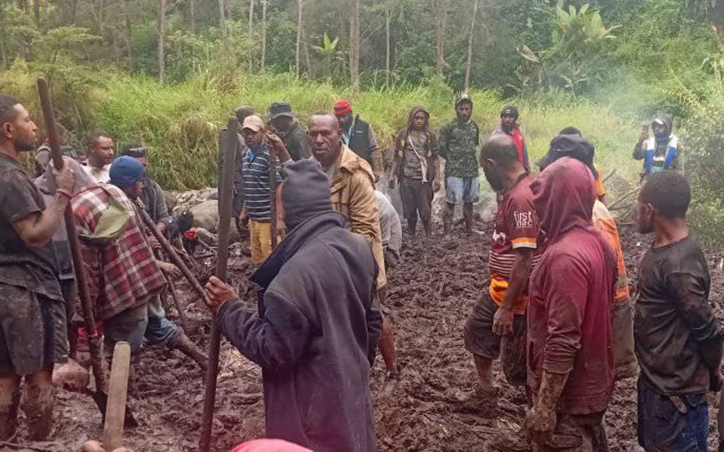 Villagers work to recover bodies after a landslide in Papua New Guinea's Enga province.