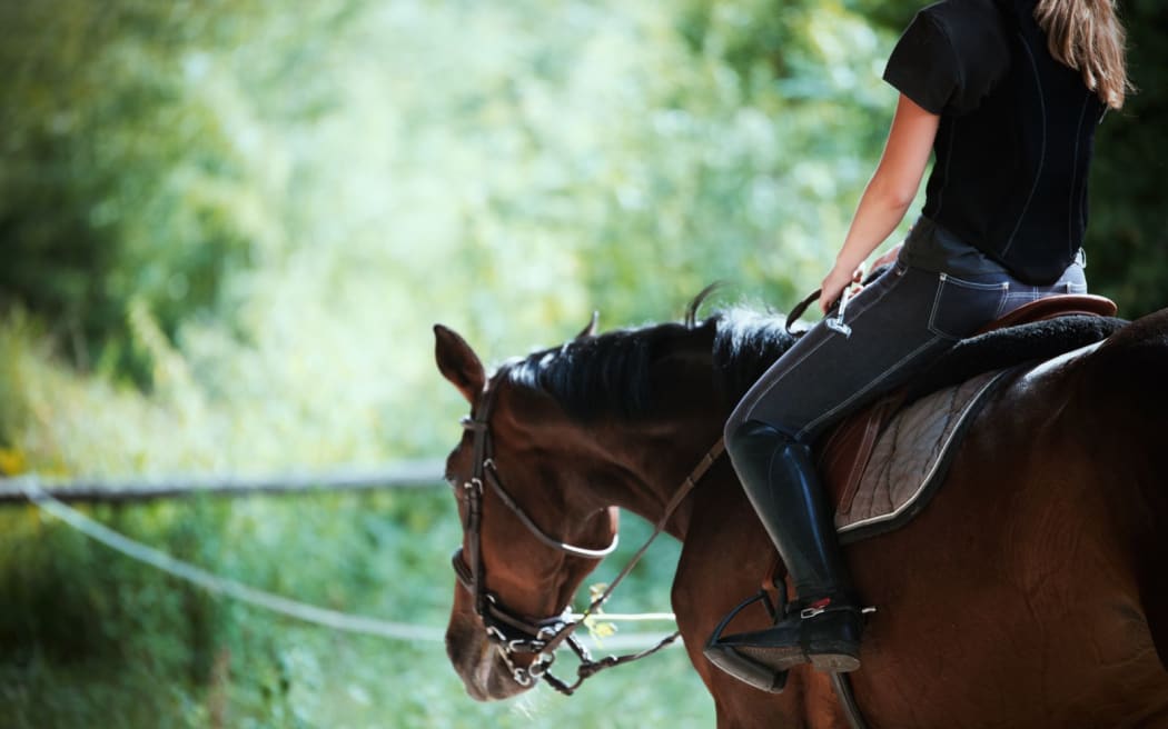 Portrait of young woman riding her horse.