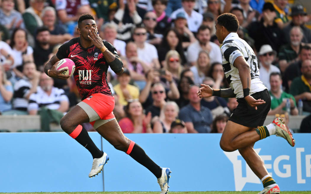 Fiji's prop Epeli Momo (L) blows a kiss as he runs past Barbarian's New Zealand full back Chay Fihaki during the International rugby union match between Barbarians and Fiji at Twickenham Stadium, south-west London, on June 22, 2024. (Photo by Glyn KIRK / AFP)