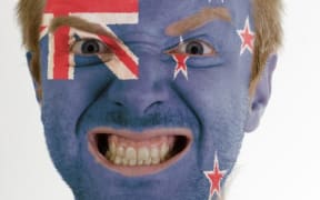 NZ sports supporter with face painted like NZ flag.