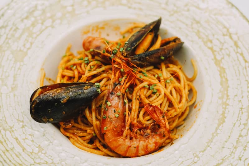 A plate of spaghetti with seafood and tomato sauce.