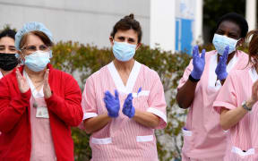 Health workers at the Puerta de Hierro hospital in Madrid on 5 March 2020 respond to applause in support of their work during the Covid-19 pandemic.