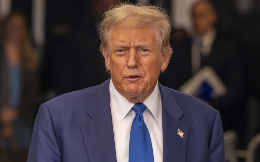 Former US President Donald Trump, with his lawyers, talks to the press pool outside Manhattan Criminal Court room on 3 May, 2024 in New York City, during his trial for allegedly covering up hush money payments. Trump was charged with 34 counts of falsifying business records in 2023, which prosecutors say was an effort to hide a potential sex scandal, both before and after the 2016 presidential election. Trump is the first former US president to face trial on criminal charges.