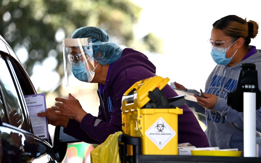 AUCKLAND, NEW ZEALAND - SEPTEMBER 25: A nurse hands out information after vaccinating a member of the public in their car during the Cook Islands drive through vaccination community event on September 25, 2021 in Auckland,